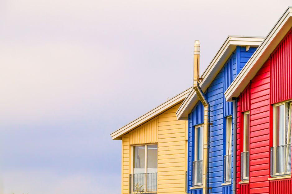 Vibrant red, blue, and yellow modern houses with clear sky backdrop