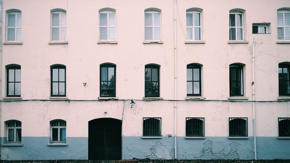 Front view of a vintage apartment facade with symmetrical windows.
